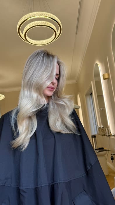 Blondes Haar unter dem Kronleuchter des Salons